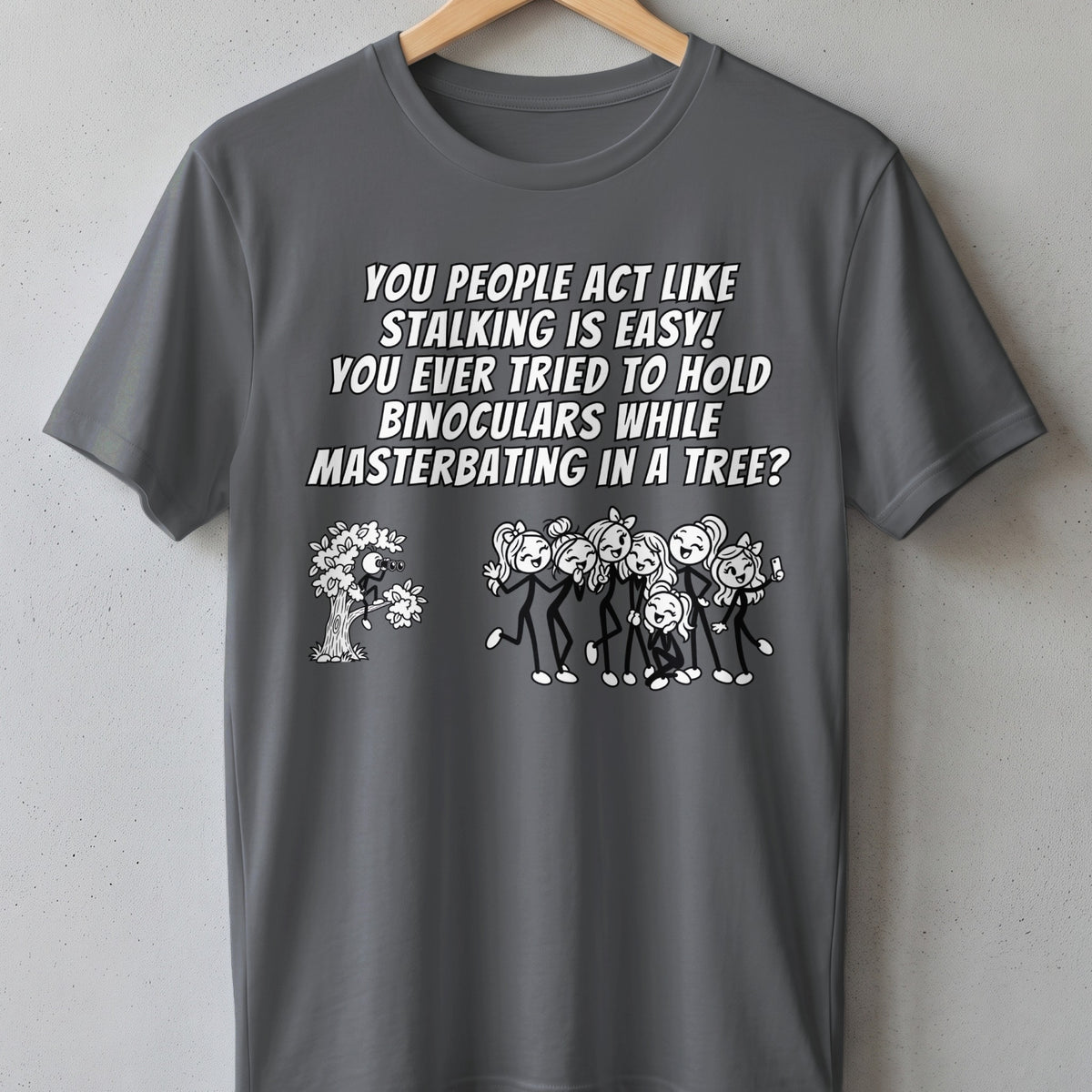 T-shirt with text and cartoon: person in tree with binoculars watches group of stick figures.