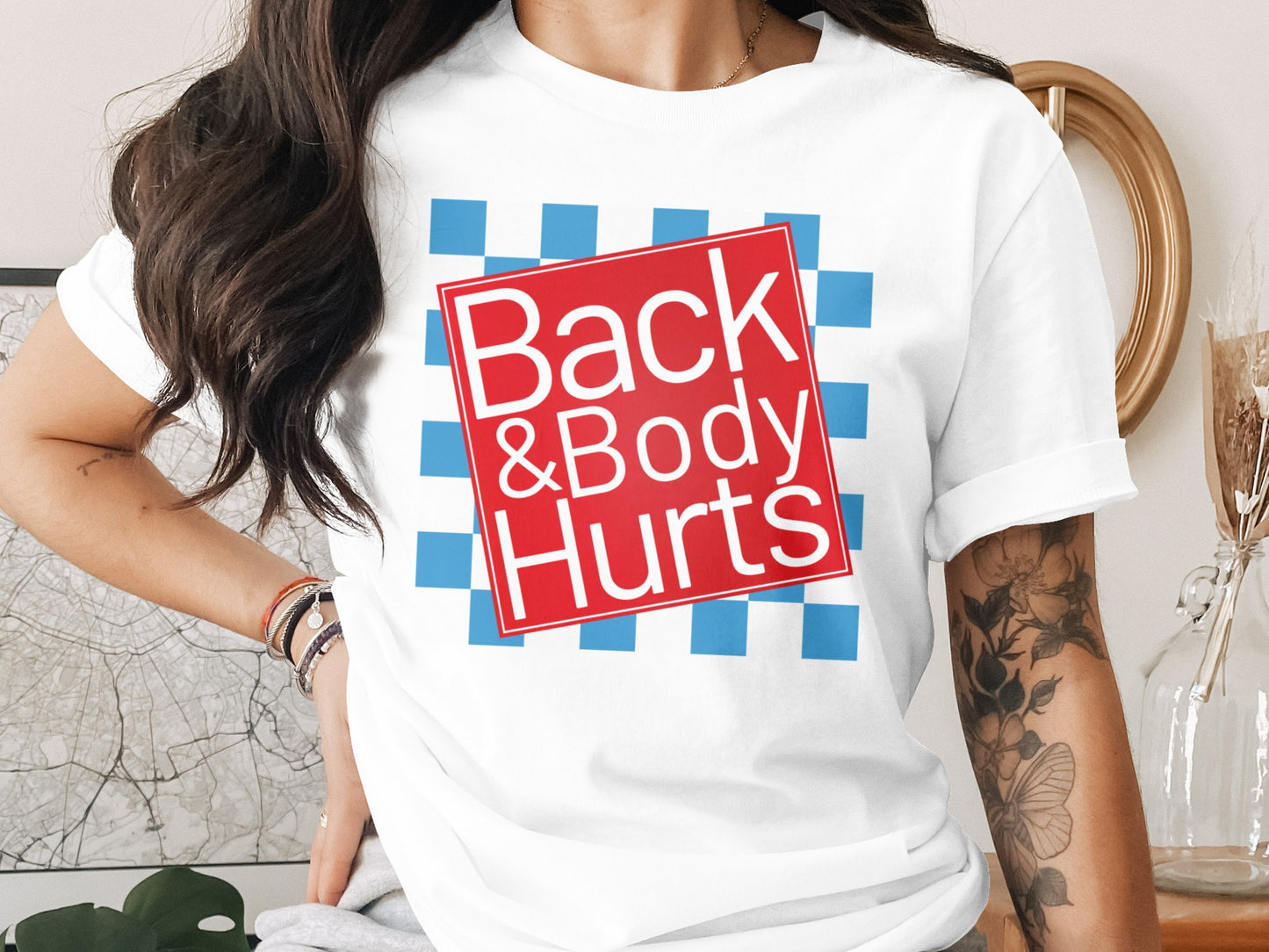 White t-shirt with red square graphic featuring white text "Back &Body Hurts".