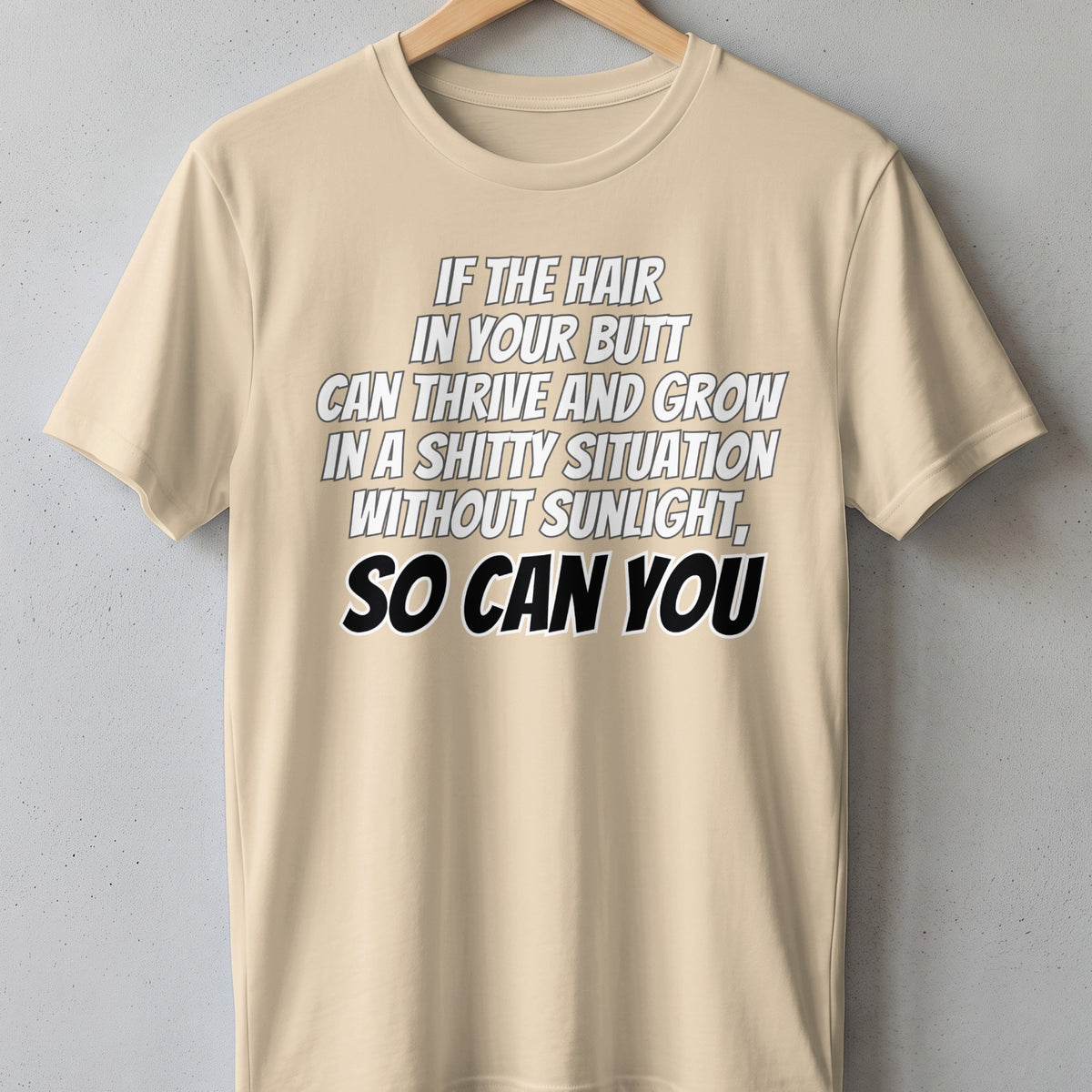 Tan t-shirt with white and black text: "If the hair in your butt can thrive and grow in a shitty situation without sunlight, so can you."