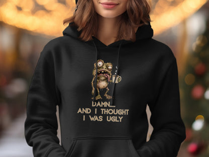 Black hoodie with graphic of a grotesque frog holding a coffee cup and text.