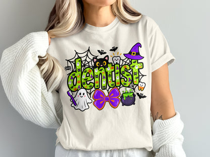A person wears a white t-shirt featuring a green Halloween-themed dentist graphic with a witch hat.