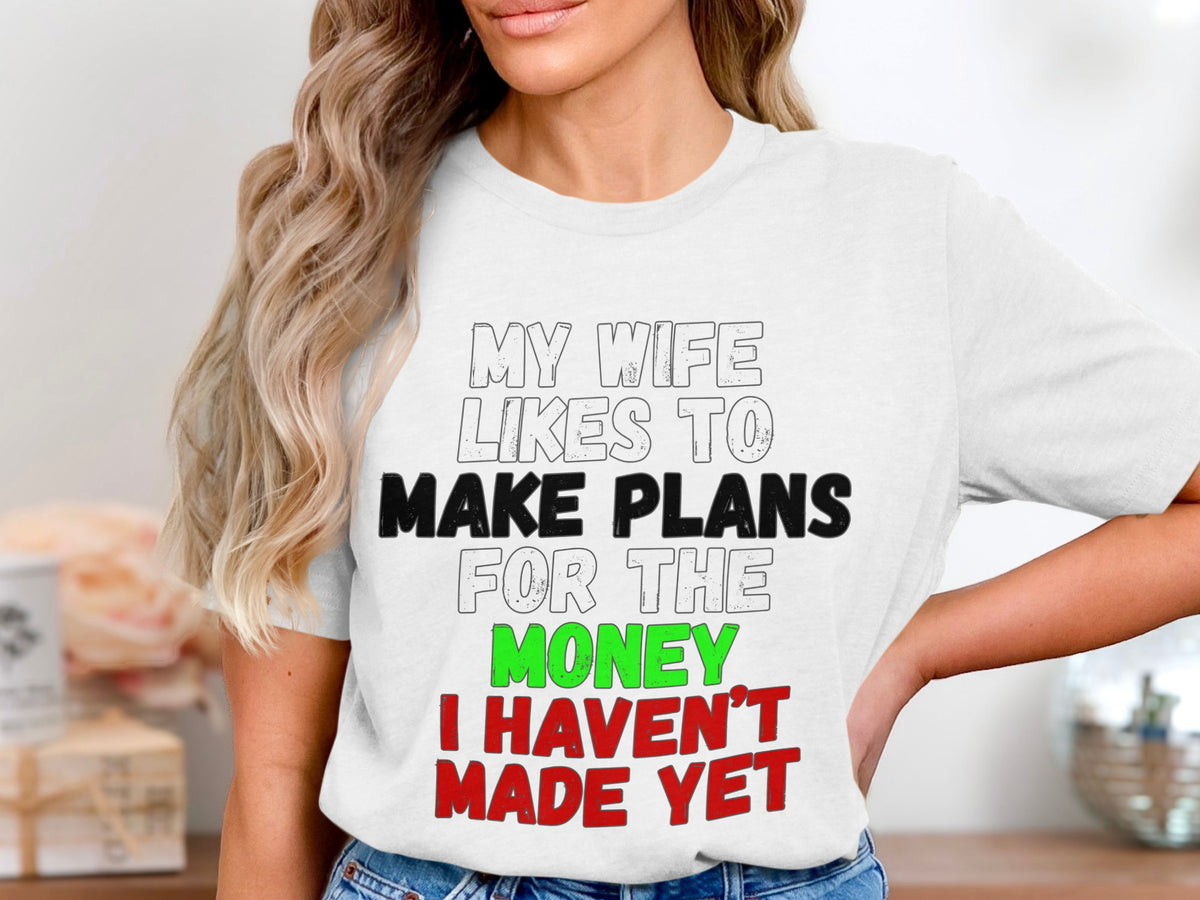 White t-shirt with text "MY WIFE LIKES TO MAKE PLANS FOR THE MONEY I HAVEN'T MADE YET".