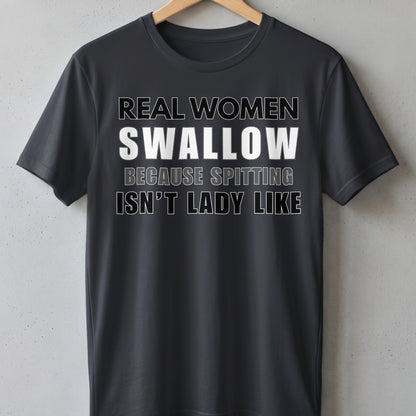 Dark t-shirt with white text "REAL WOMEN SWALLOW BECAUSE SPITTING ISN'T LADY LIKE".
