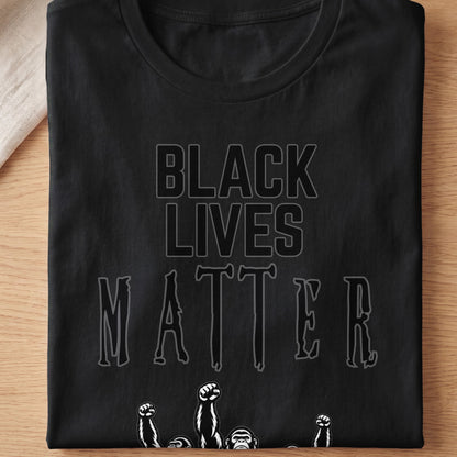 Black Lives Matter text with raised fists and ape faces on black t-shirt.