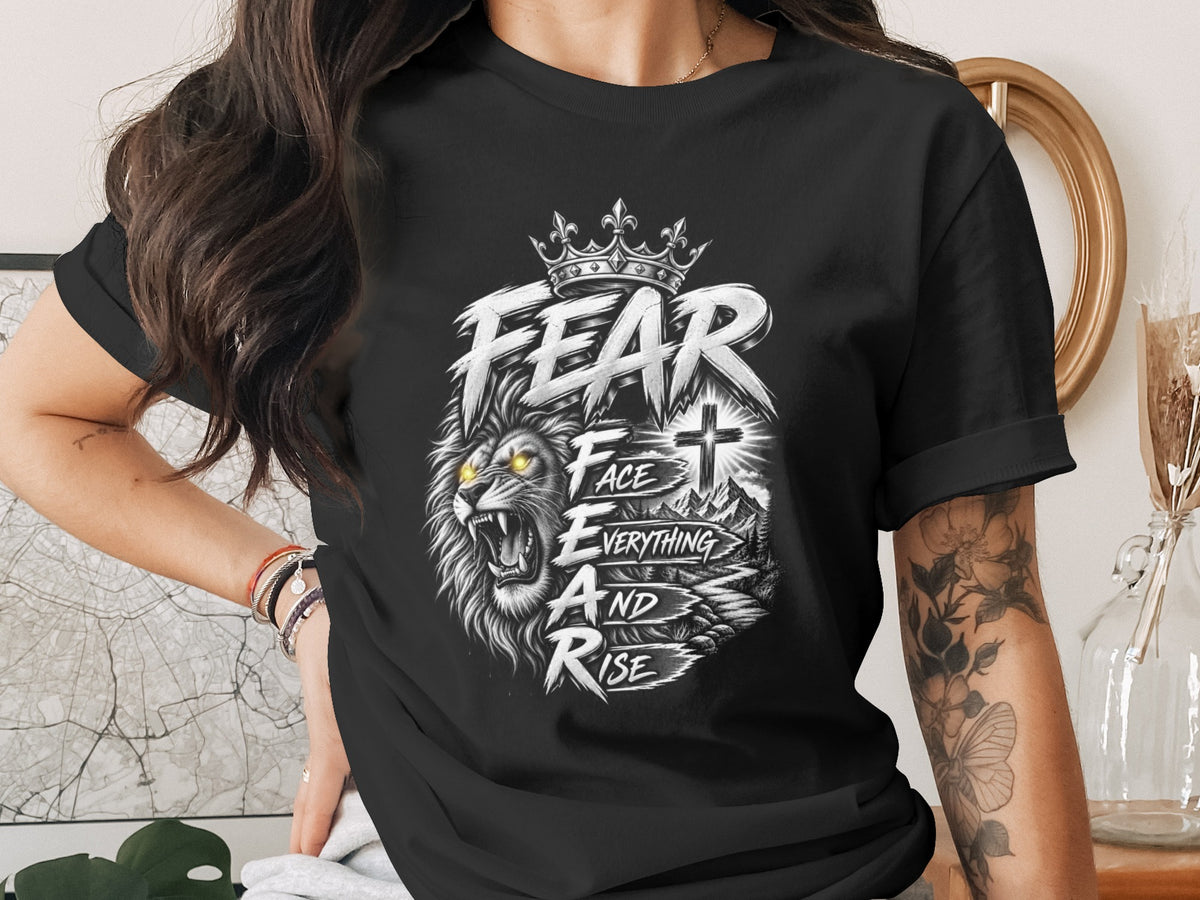 Black t-shirt with roaring lion, crown, cross, and text "FEAR FACE EVERYTHING AND RISE".