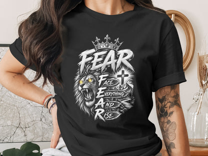 Black t-shirt with roaring lion, crown, cross, and text "FEAR FACE EVERYTHING AND RISE".