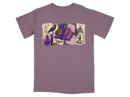 Dark purple t-shirt with witchy graphic featuring open book, raven, skull, and potion.