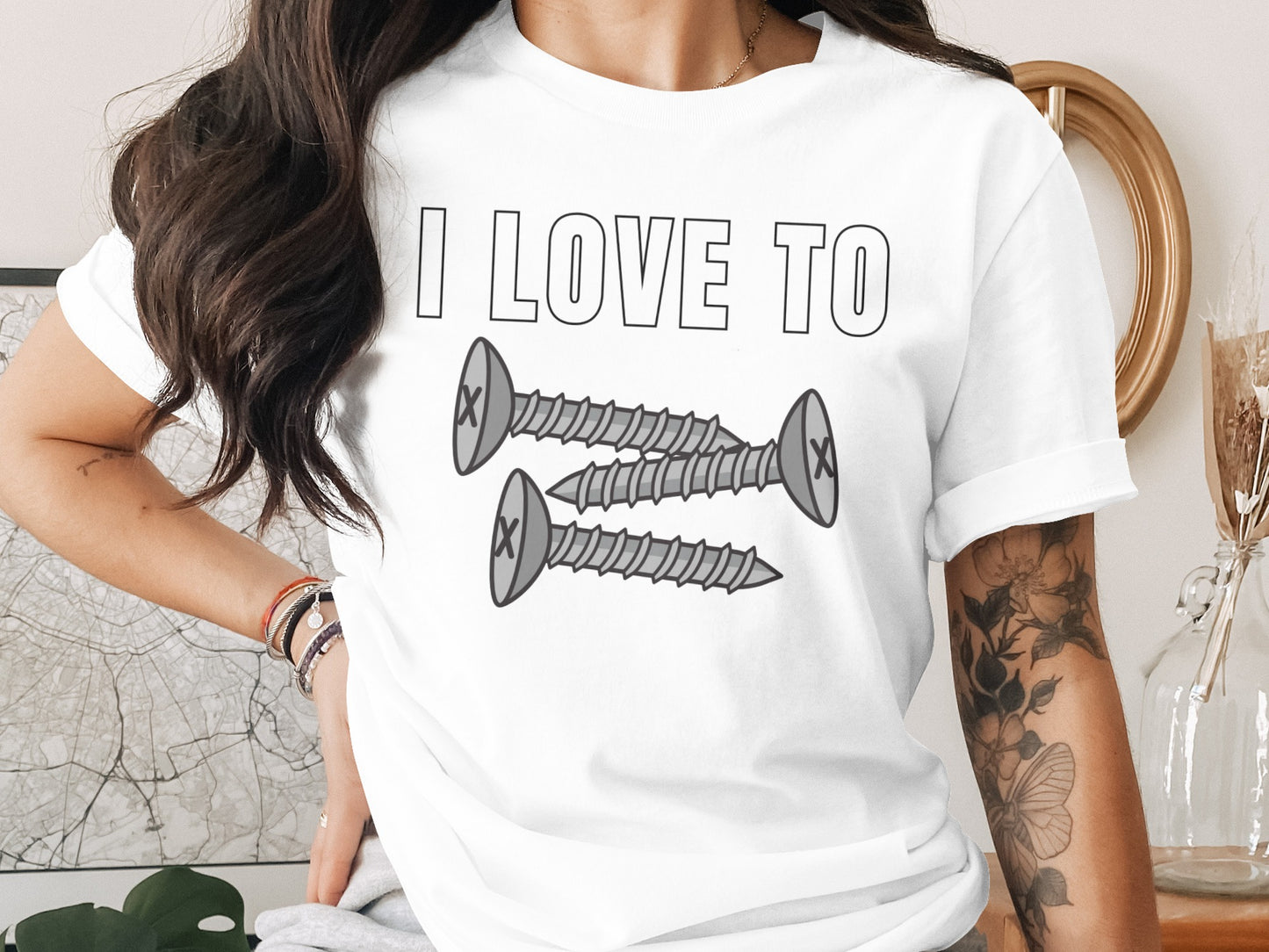 White t-shirt with "I LOVE TO" and two cartoon screws graphic.