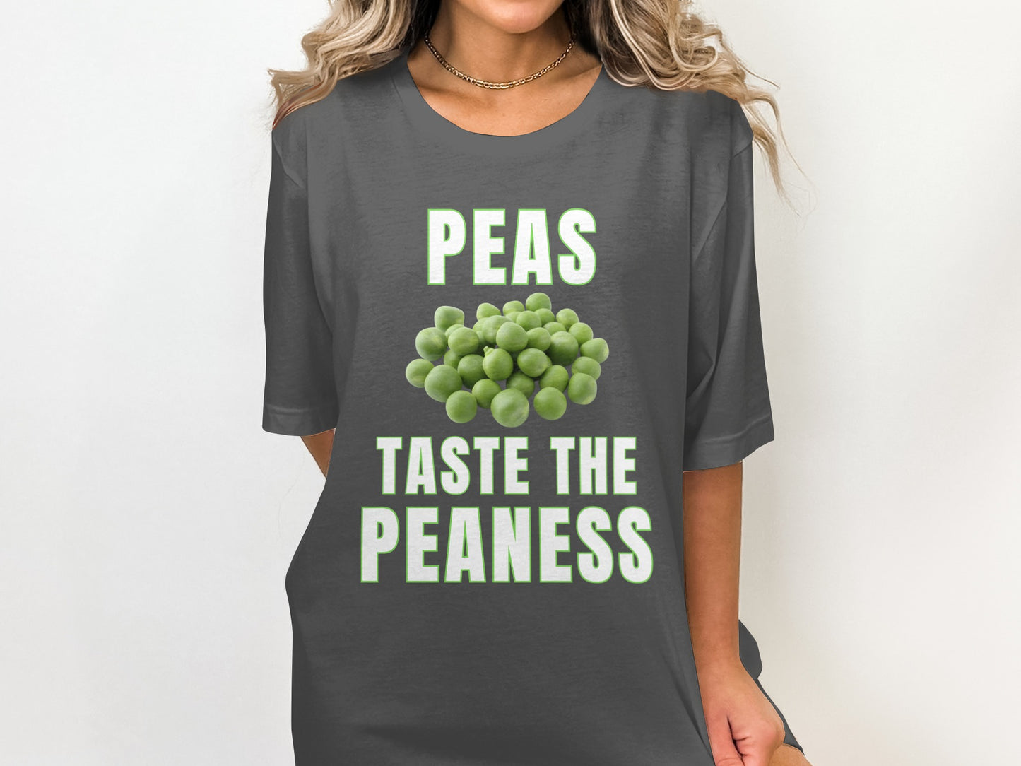 Dark grey t-shirt with text "PEAS TASTE THE PEANESS" and pile of peas graphic.