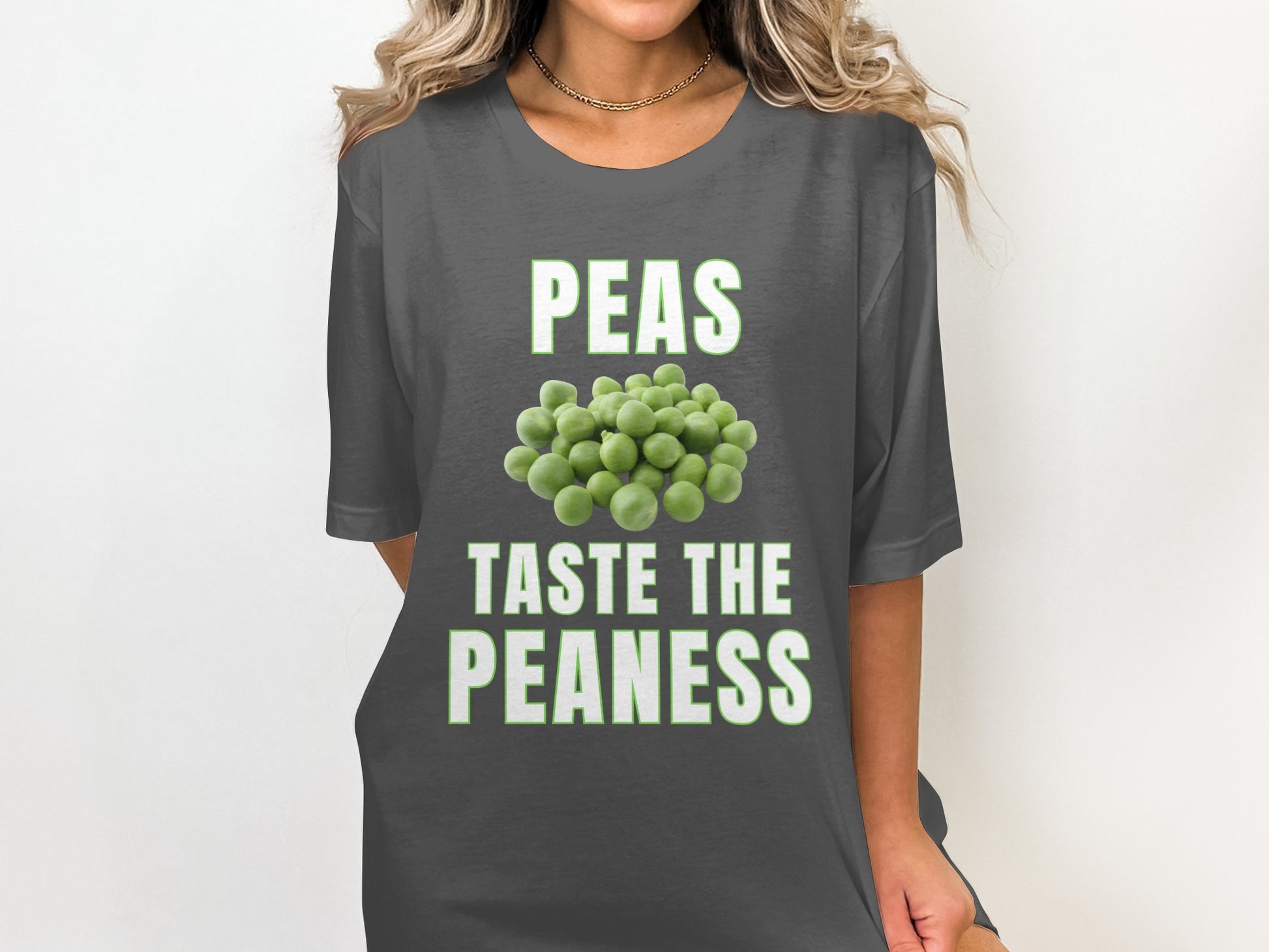 Dark grey t-shirt with text "PEAS TASTE THE PEANESS" and pile of peas graphic.