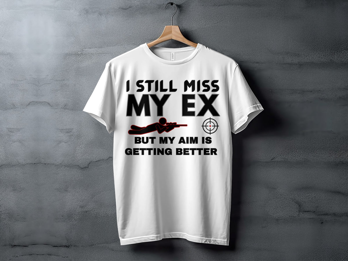 White t-shirt with black text reading "I STILL MISS MY EX BUT MY AIM IS GETTING BETTER".