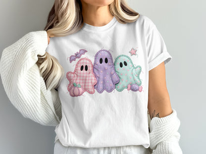 Three pastel ghosts with embroidered details on a white t-shirt.