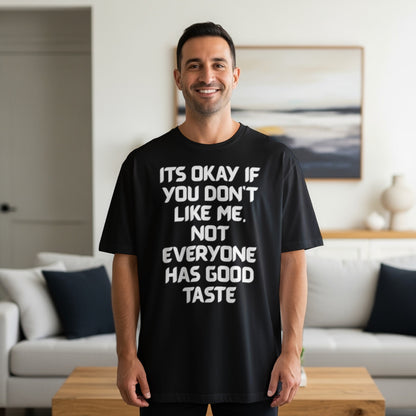Black t-shirt with white text that says "It's Okay If You Don't Like Me. Not Everyone Has Good Taste."