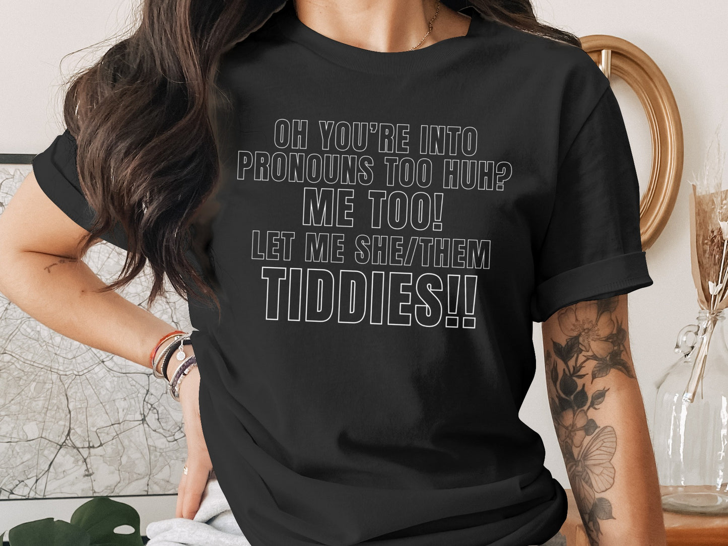Black t-shirt with white text: "OH YOU'RE INTO PRONOUNS TOO HUH? ME TOO! LET ME SHE/THEM TIDDIES!!"