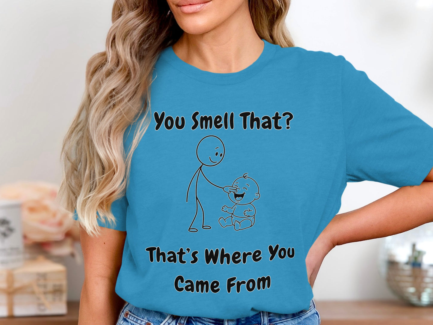Turquoise t-shirt with text and stick figures saying "You Smell That? That's Where You Came From."