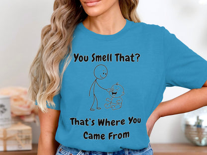 Turquoise t-shirt with text and stick figures saying "You Smell That? That's Where You Came From."