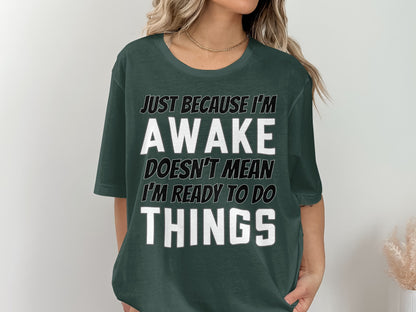 Green t-shirt with text: "JUST BECAUSE I'M AWAKE DOESN'T MEAN I'M READY TO DO THINGS."