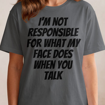 Dark grey t-shirt with black text: "I'M NOT RESPONSIBLE FOR WHAT MY FACE DOES WHEN YOU TALK"