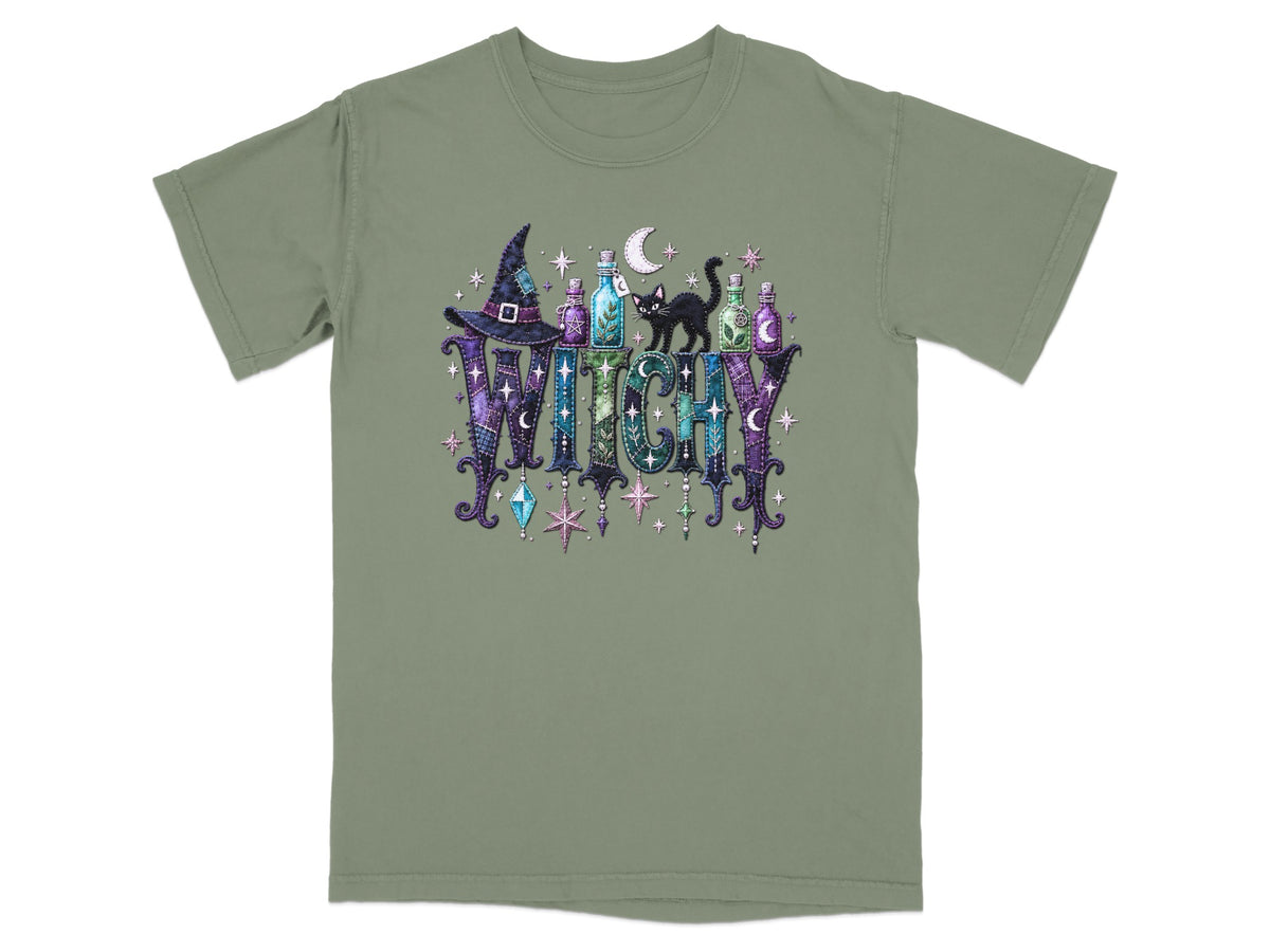 Green t-shirt with a "Witchy" graphic featuring a witch hat, potion bottles, a black cat, and stars.