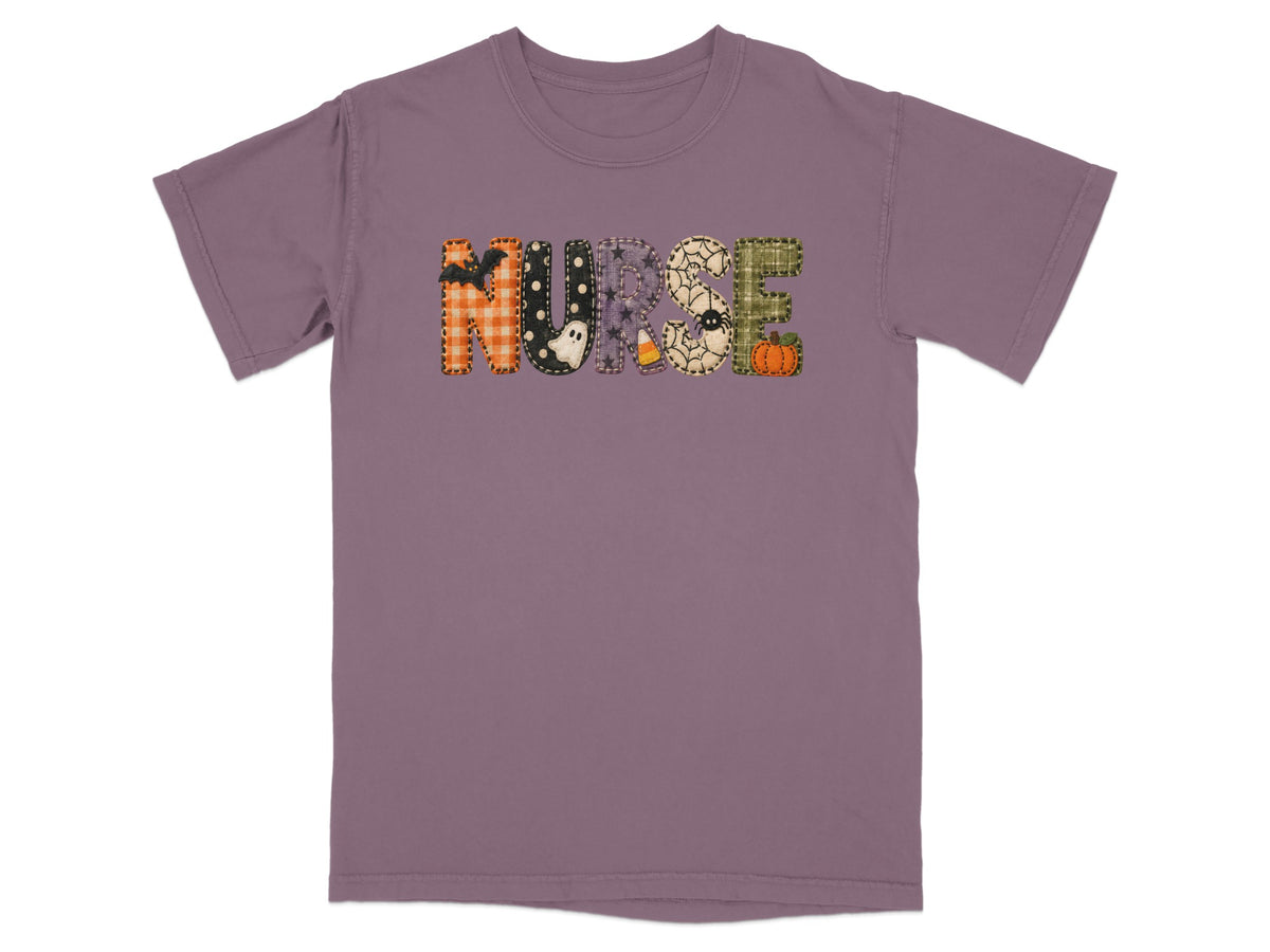 A short-sleeve purple t-shirt featuring the word NURSE in Halloween-themed patchwork letters across the chest.