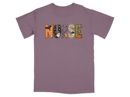 A short-sleeve purple t-shirt featuring the word NURSE in Halloween-themed patchwork letters across the chest.