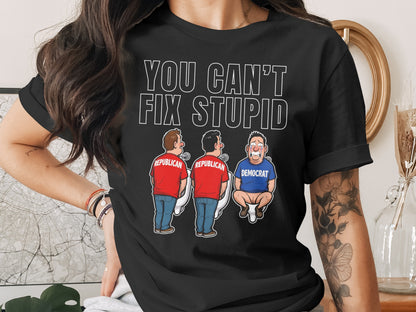 Black t-shirt with "YOU CAN'T FIX STUPID" and cartoon of two Republicans and one Democrat on toilets.