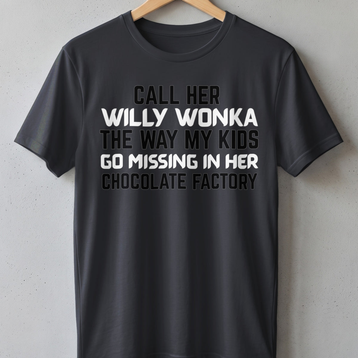 Dark grey t-shirt with white text: Call her Willy Wonka the way my kids go missing in her chocolate factory.