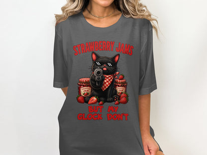 Black cat with sunglasses holds gun, between strawberry jam jars, on a t-shirt.