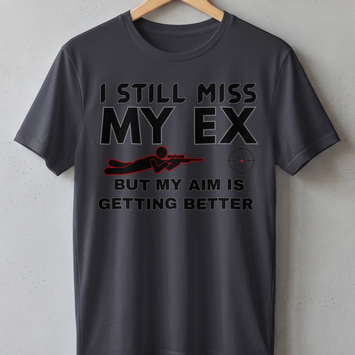 Dark grey t-shirt with text "I STILL MISS MY EX BUT MY AIM IS GETTING BETTER" and sniper graphic.