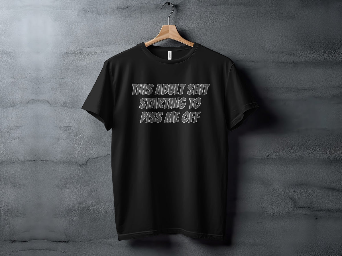 Black t-shirt with white text "THIS ADULT SHIT STARTING TO PISS ME OFF"