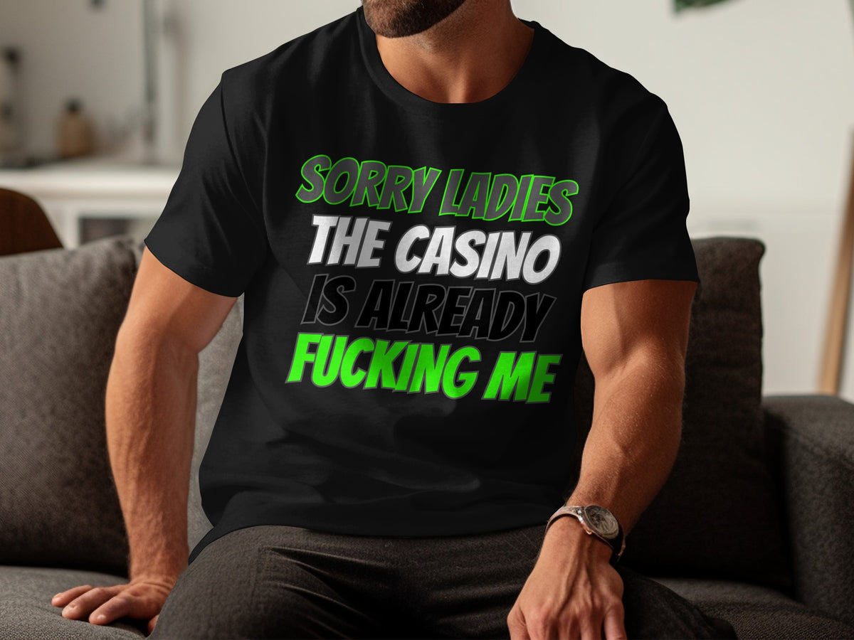 Black t-shirt with green and white text reading "SORRY LADIES THE CASINO IS ALREADY FUCKING ME".