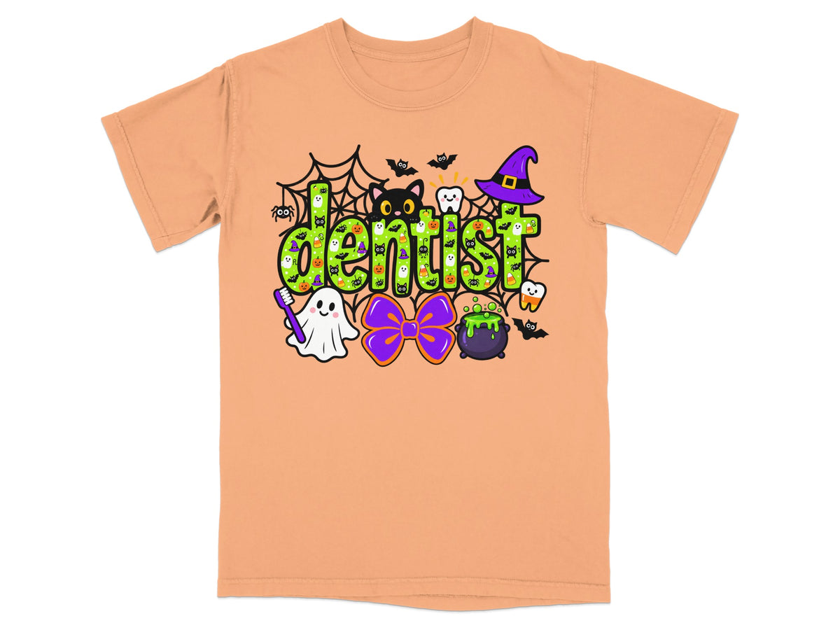 A peach short-sleeve t-shirt features a colorful Halloween-themed graphic with the word "dentist" in green letters.