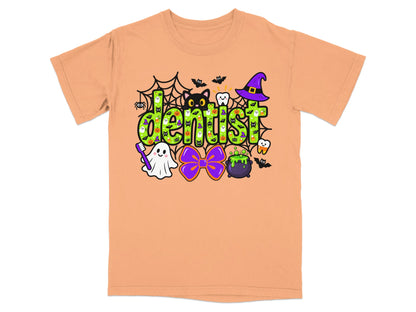 A peach short-sleeve t-shirt features a colorful Halloween-themed graphic with the word "dentist" in green letters.