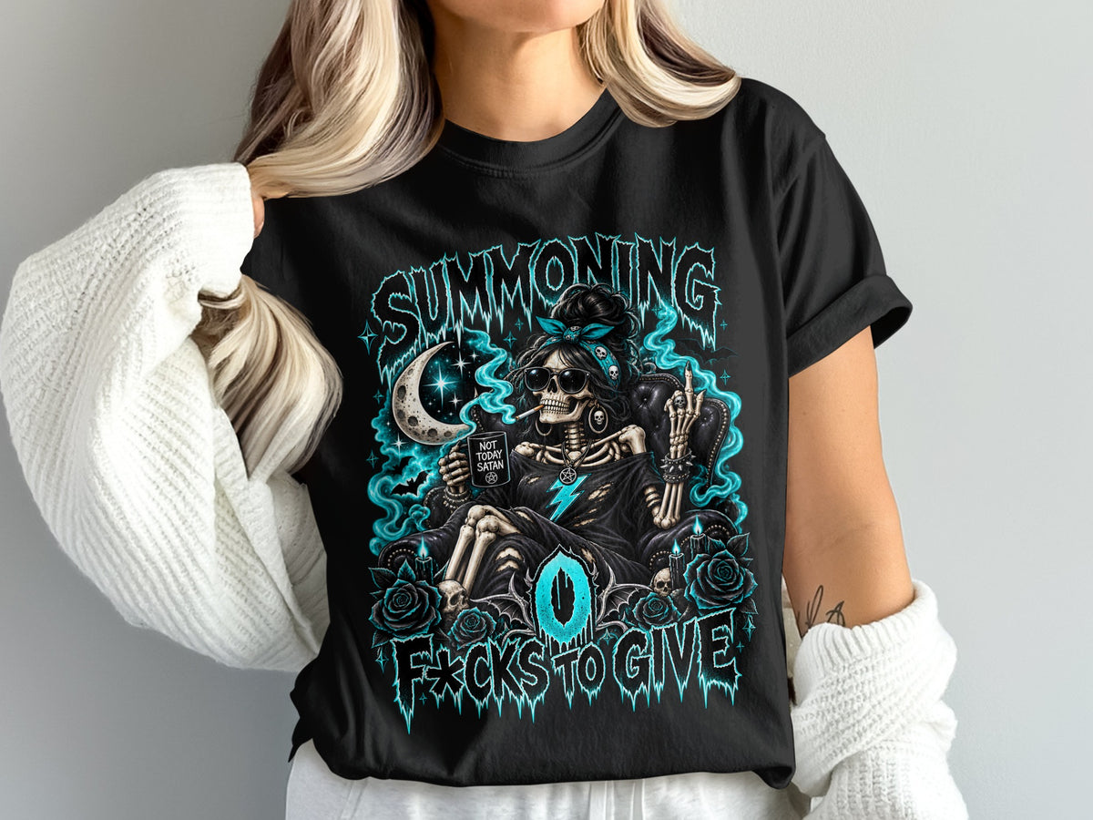 A person wears a black t-shirt printed with a skeleton graphic, glowing blue smoke, and text reading Summoning Zero F*cks to Give.