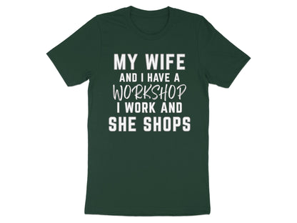 Dark green t-shirt with white text: "My wife and I have a workshop. I work and she shops."
