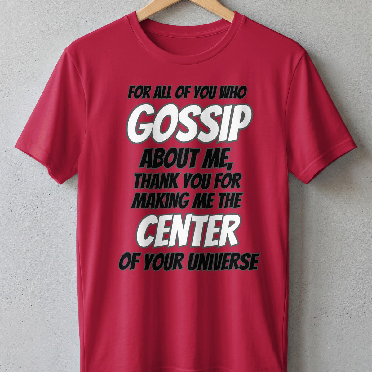 Red t-shirt with text: "FOR ALL OF YOU WHO GOSSIP ABOUT ME, THANK YOU FOR MAKING ME THE CENTER OF YOUR UNIVERSE."