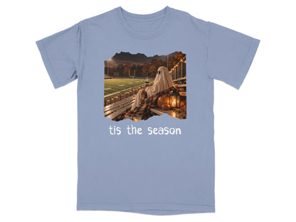 Ghost in a sheet sits on stadium bleachers holding a drink, with "tis the season" text.