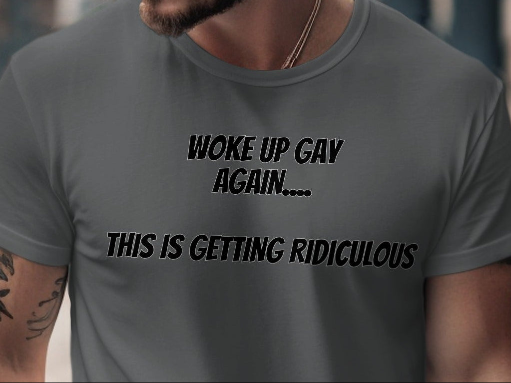 Grey t-shirt with black text reading "WOKE UP GAY AGAIN.... THIS IS GETTING RIDICULOUS".