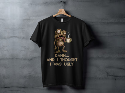 Black t-shirt with a grotesque frog character holding a coffee cup and text.