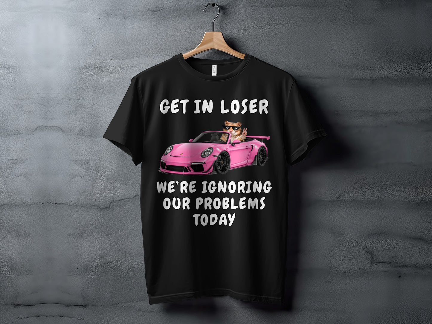 Black t-shirt with a cat in a pink sports car, text "GET IN LOSER WE'RE IGNORING OUR PROBLEMS TODAY".