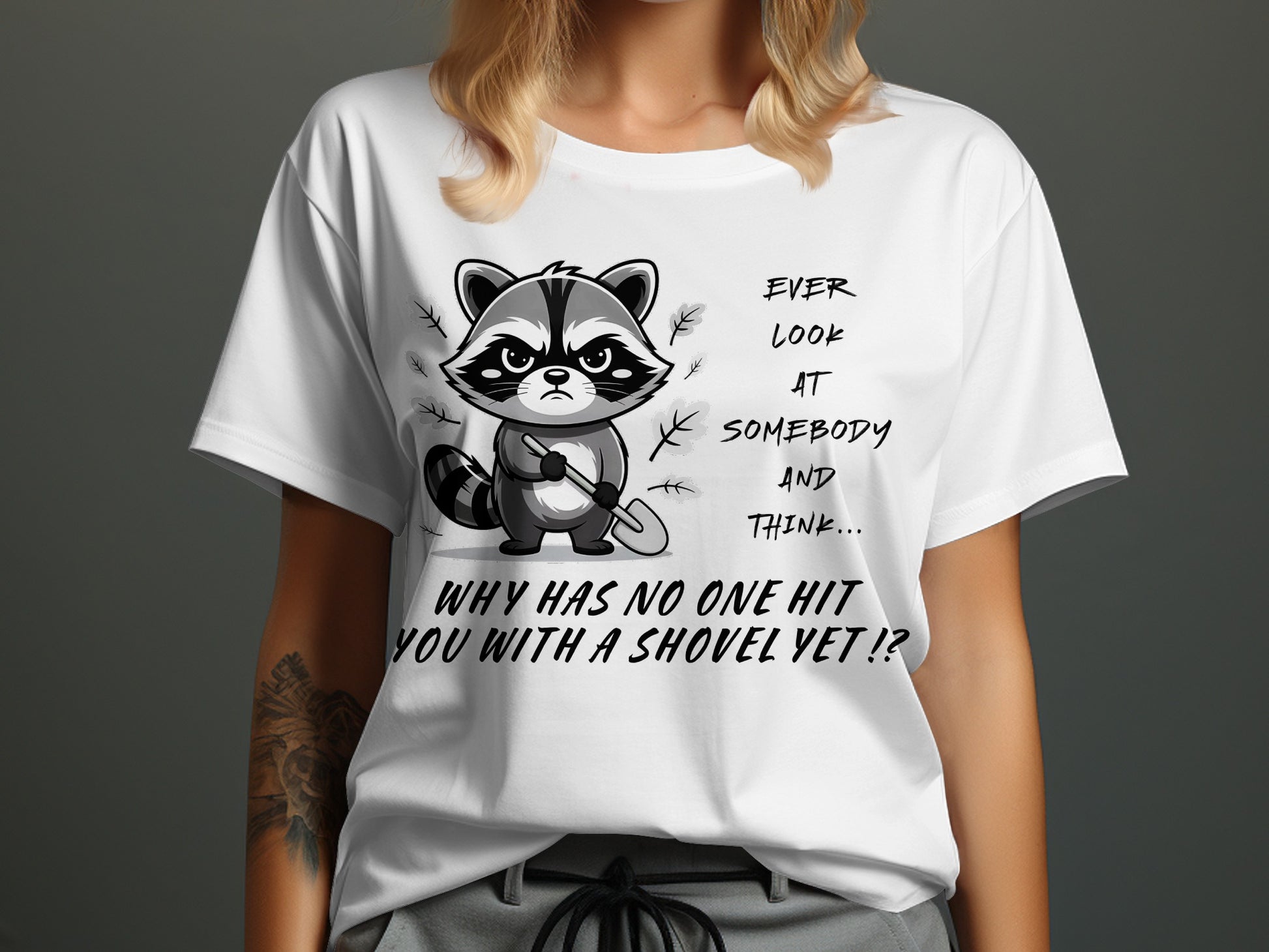 T-shirt with grumpy raccoon holding shovel and text "Ever look at somebody and think... why has no one hit you with a shovel yet!?"