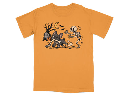 French bulldog chases skeleton holding a bone near tombstone and pumpkin.