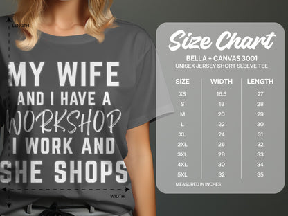 Gray t-shirt with white text: "MY WIFE AND I HAVE A WORKSHOP I WORK AND SHE SHOPS". Size chart on right.