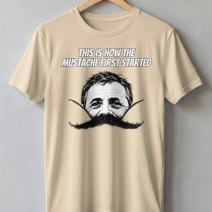 Cream t-shirt with "This is how the mustache first started" and a man's face with a large mustache.