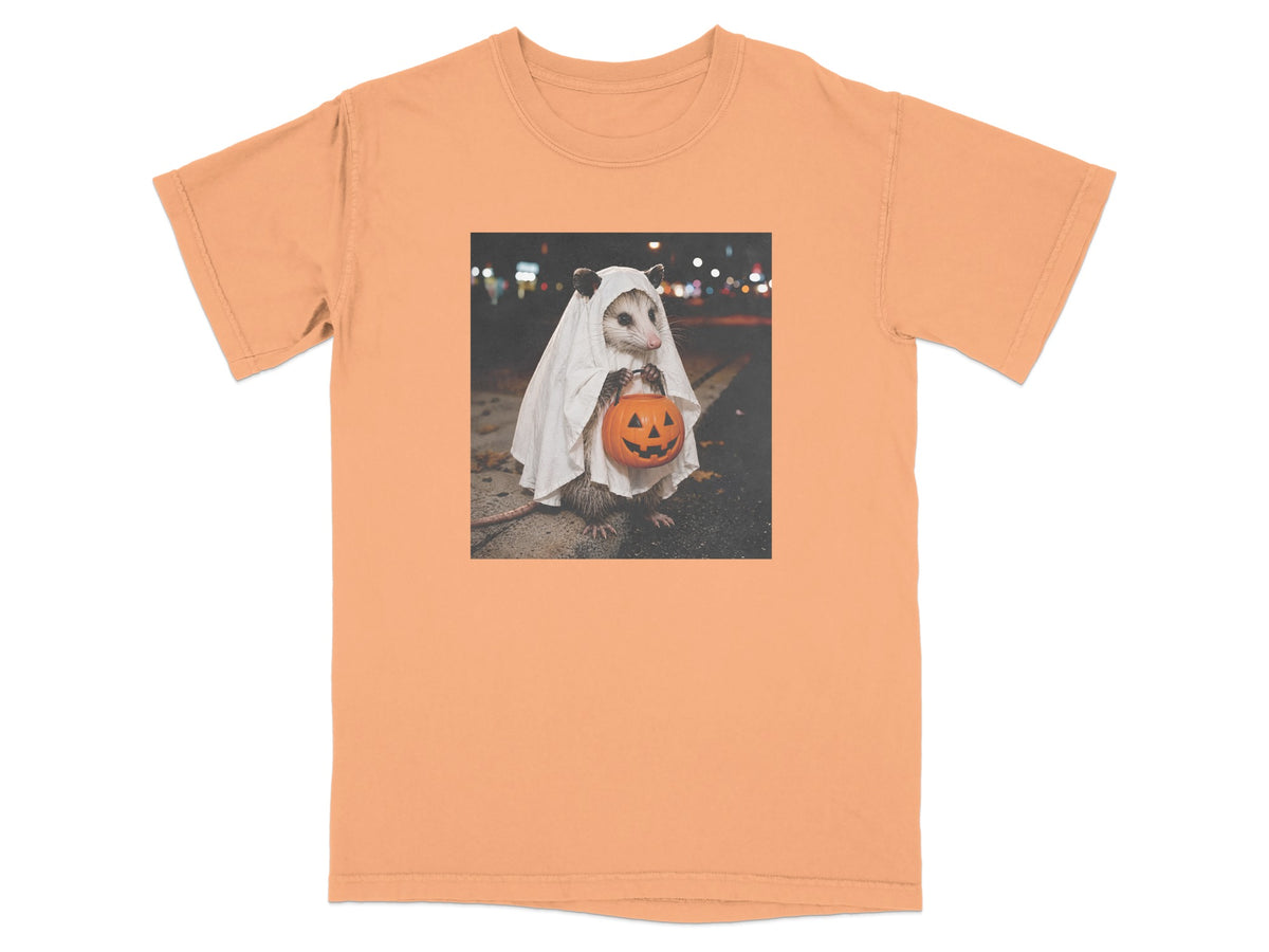 Opossum in ghost costume holding a pumpkin candy bucket at night.