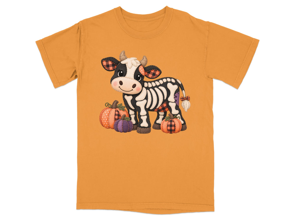Skeleton cow with pumpkins, wearing plaid accents on an orange t-shirt.