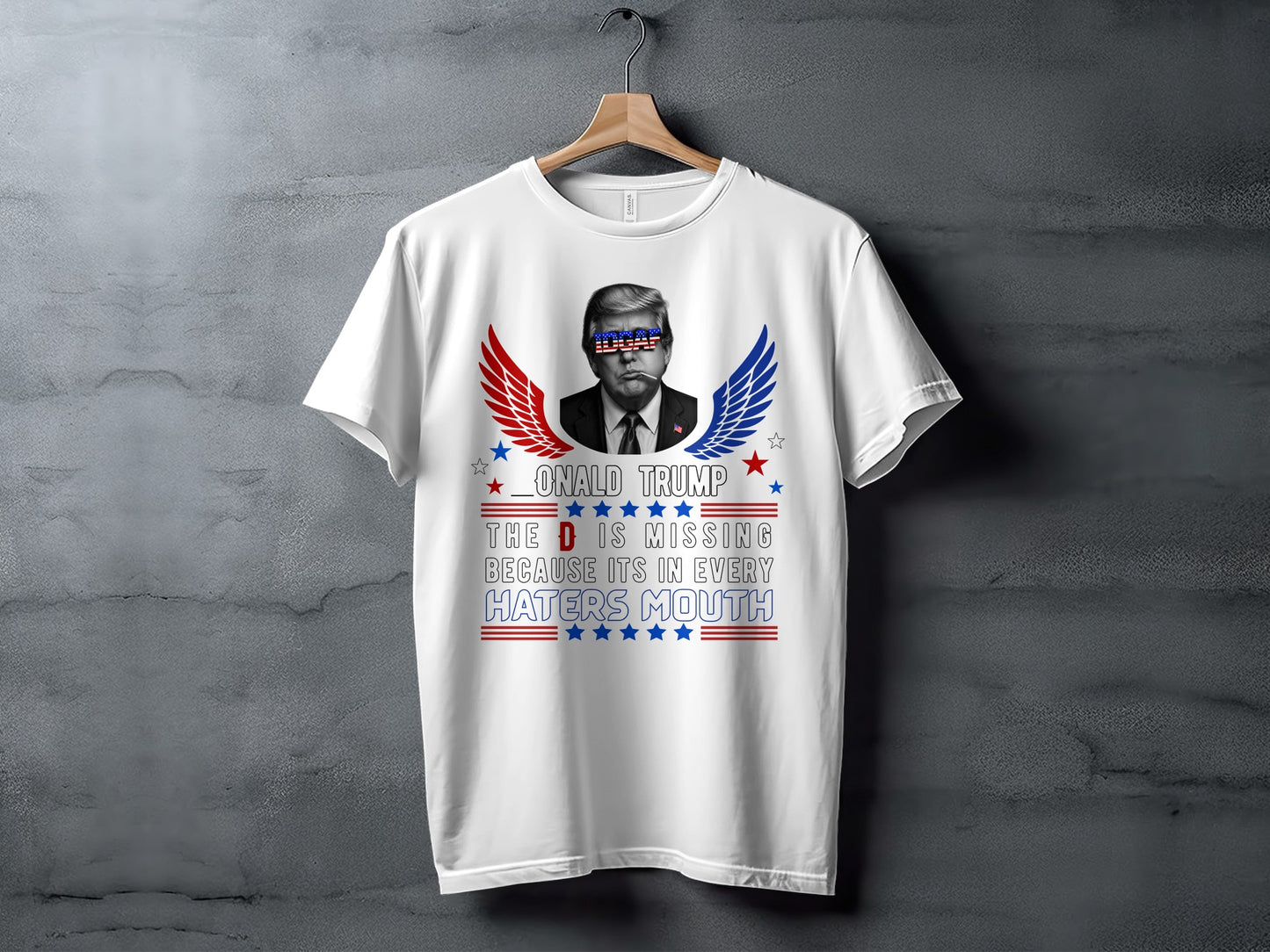White t-shirt with Donald Trump graphic and text "The D is missing because it's in every haters mouth."