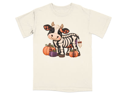 Skeleton cow with plaid ears and pumpkins, cream t-shirt graphic.