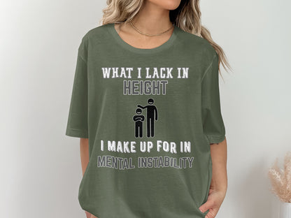 Olive green t-shirt with text "What I lack in height" and stick figures, "I make up for in mental instability".