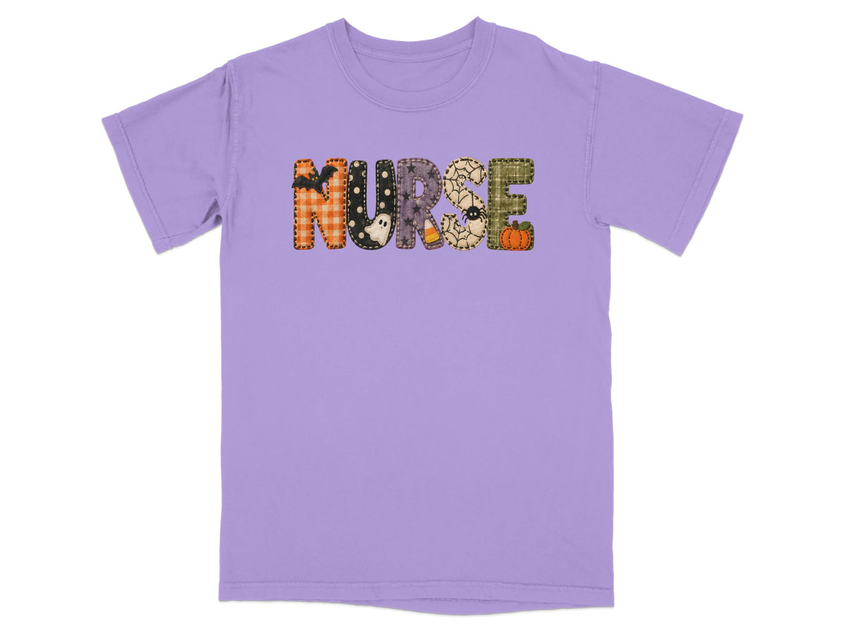 A short-sleeved purple crewneck t-shirt featuring the word NURSE spelled out in patterned Halloween-themed block letters.